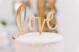 Ein goldener Hochzeitstortenaufsatz mit dem Wort Liebe.
