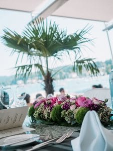 Ein gedeckter Tisch mit Blumen und einer Palme.