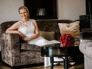 Eine Braut in einem Hochzeitskleid sitzt auf einer Couch.
