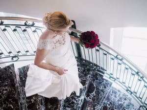 Eine Braut steht auf einer Wendeltreppe.