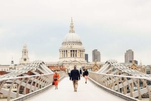 Menschen, die über eine Brücke in London gehen, mit der St. Paul's Cathedral im Hintergrund.