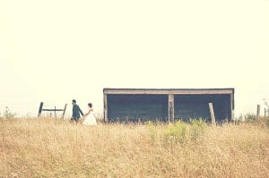 Eine Braut und ein Bräutigam stehen auf einem Feld.