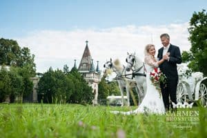 Eine Braut und ein Bräutigam stehen vor einer Pferdekutsche.