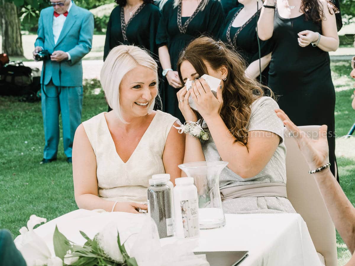 Zwei Frauen weinen, während sie an einem Tisch sitzen.