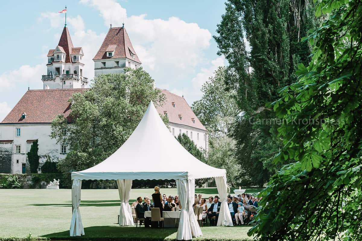 Ein weißes Zelt mit einer Burg im Hintergrund.