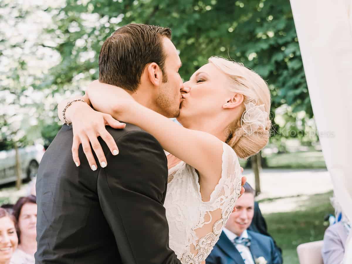 Ein Brautpaar küsst sich während der Hochzeitszeremonie.