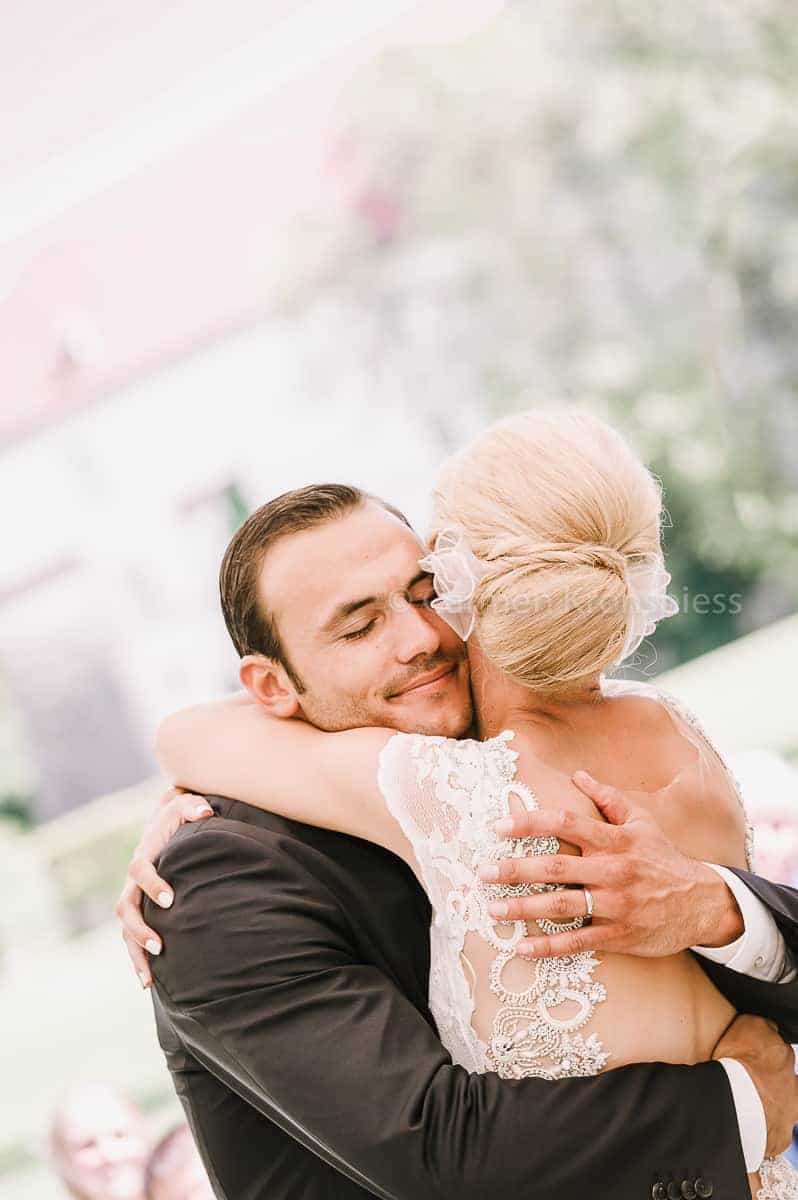 Eine Braut und ein Bräutigam umarmen sich während ihrer Hochzeitszeremonie.