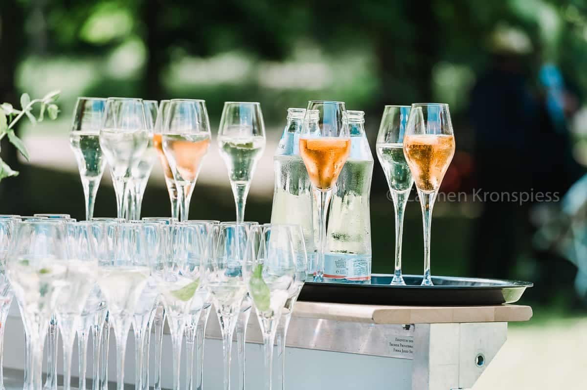 Champagnerflöten auf einem Tisch im Garten.