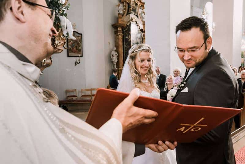 Eine Braut und ein Bräutigam geben in einer Kirche ihr Eheversprechen ab.