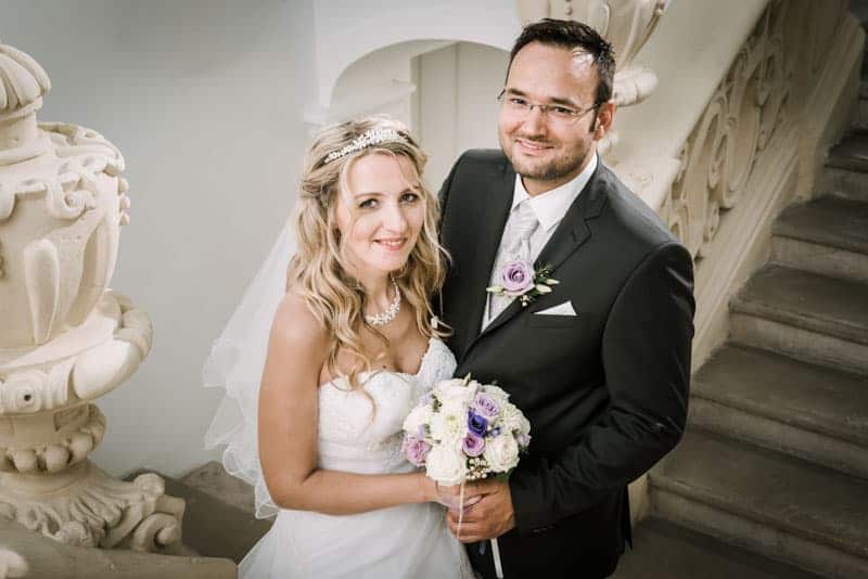 Eine Braut und ein Bräutigam stehen auf einer Treppe.