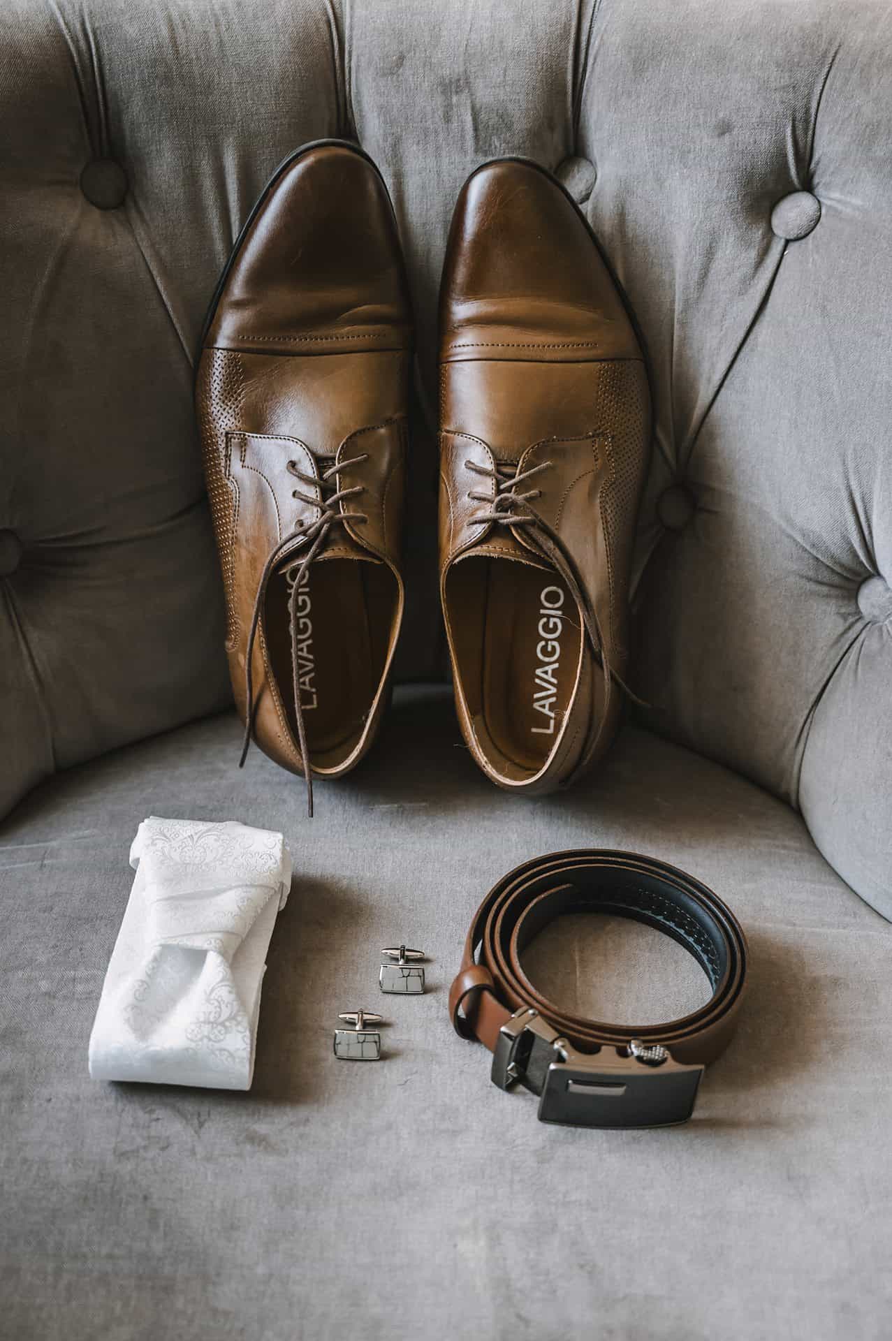 Ein Paar braune Schuhe und eine Krawatte auf einer Couch.