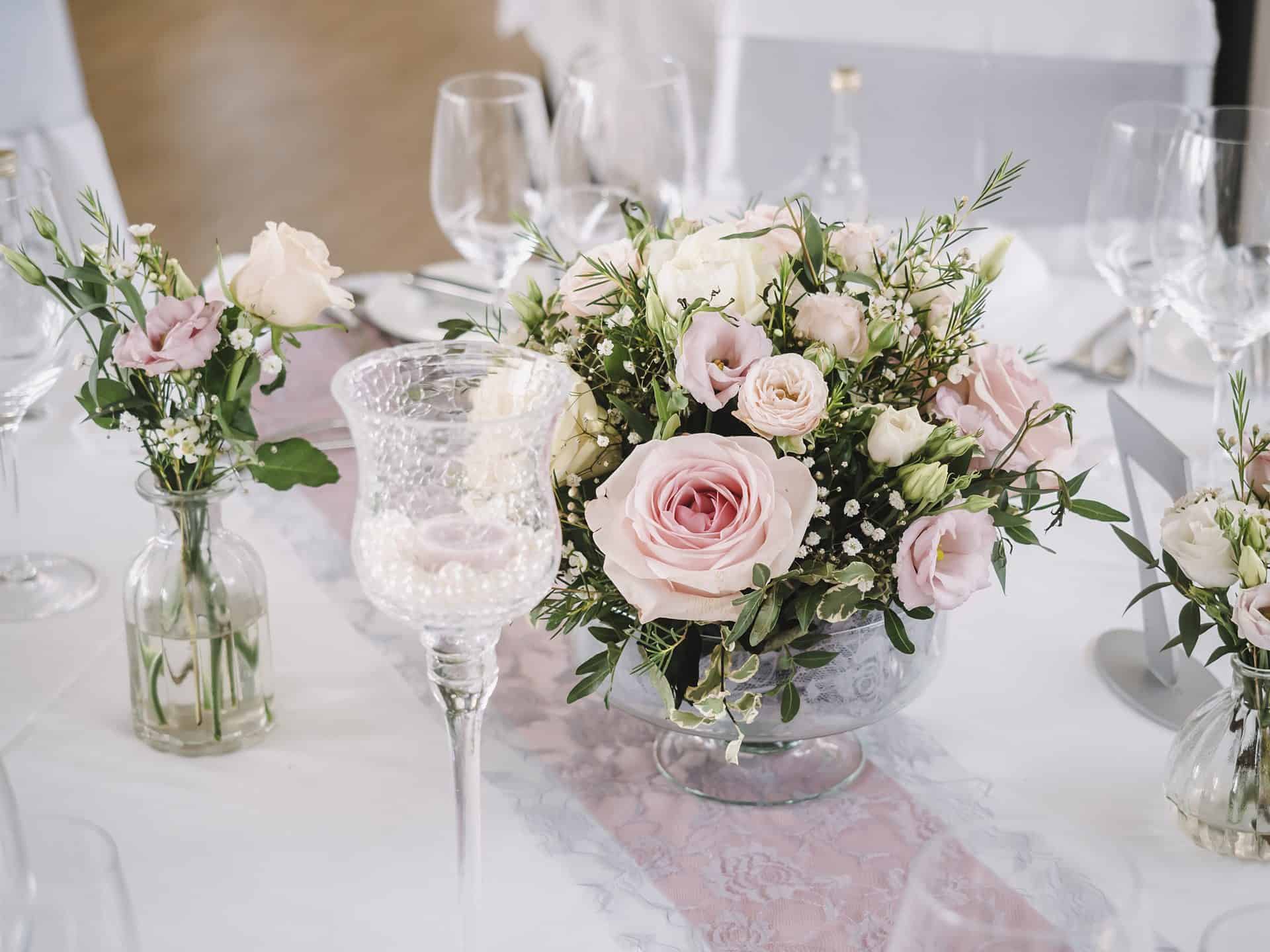Eine Tischdekoration mit rosa und weißen Blumen.