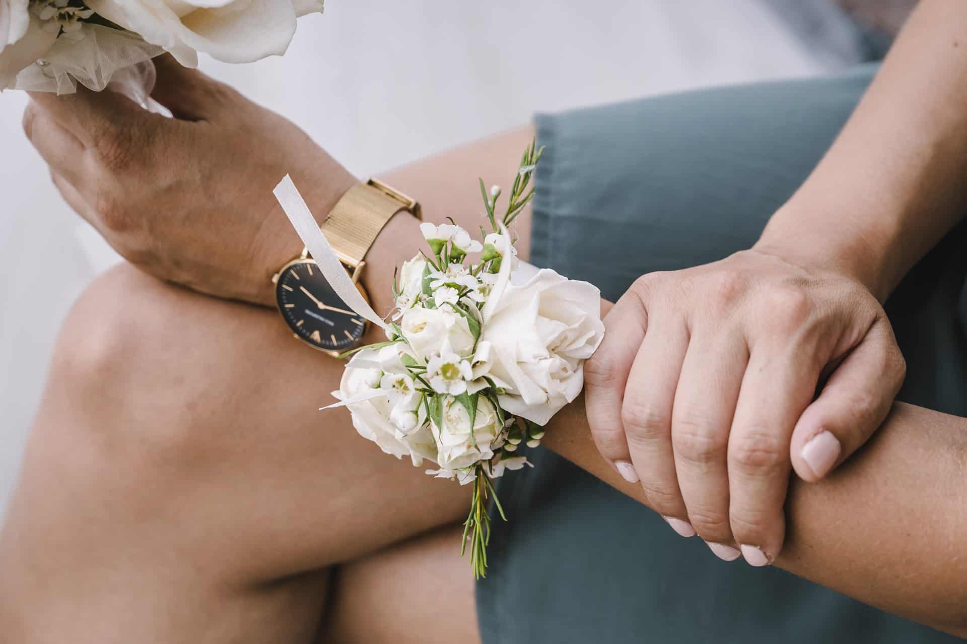 Das Handgelenk einer Frau mit Blumen und einer Uhr.