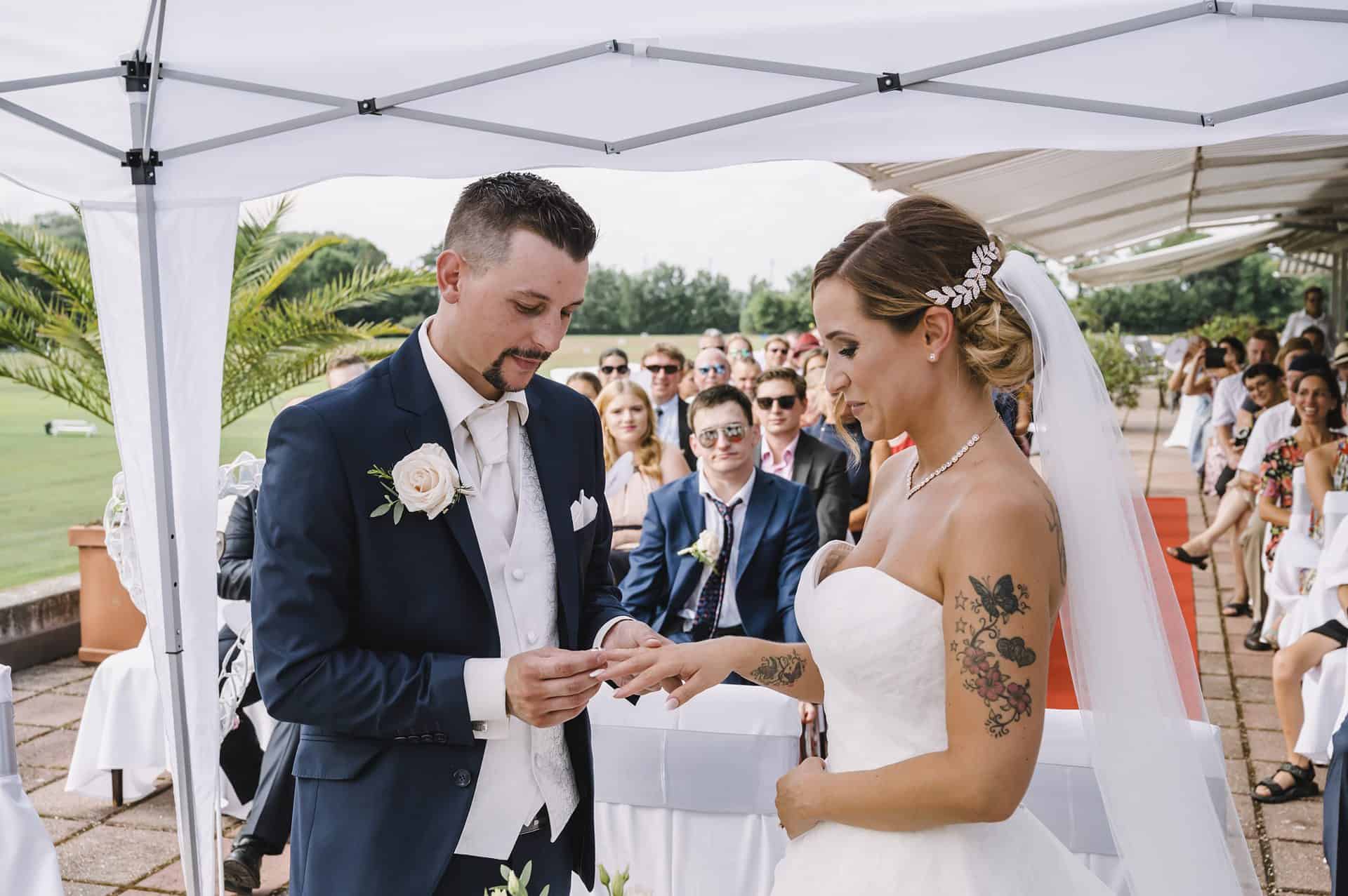 Eine Braut und ein Bräutigam tauschen bei einer Hochzeitszeremonie ihre Ringe aus.