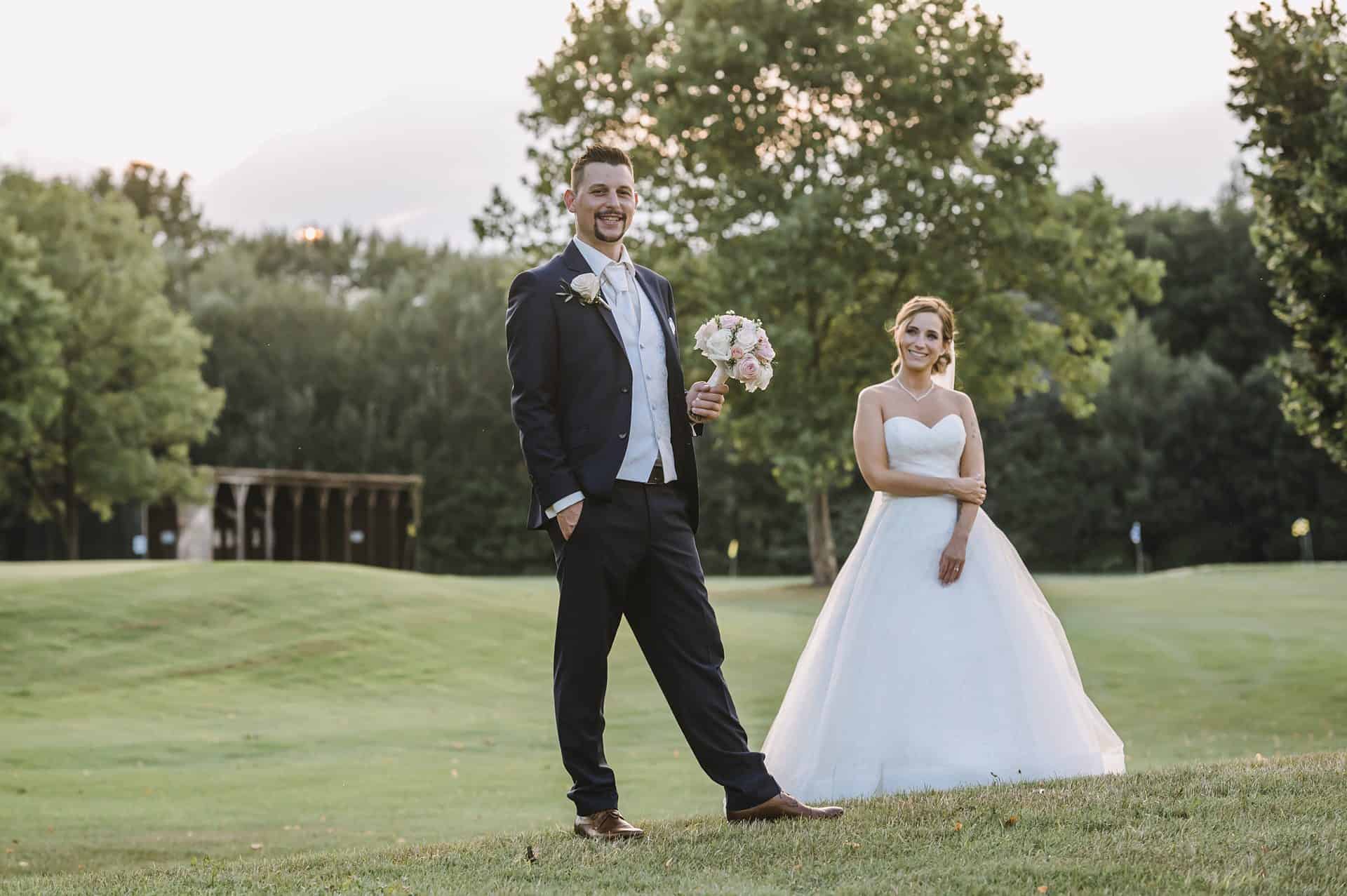 Eine Braut und ein Bräutigam stehen auf einem Golfplatz.