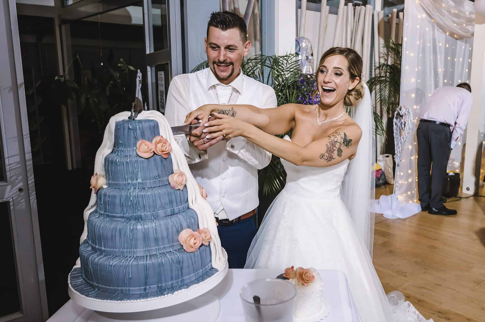 Eine Braut und ein Bräutigam schneiden eine Hochzeitstorte an.