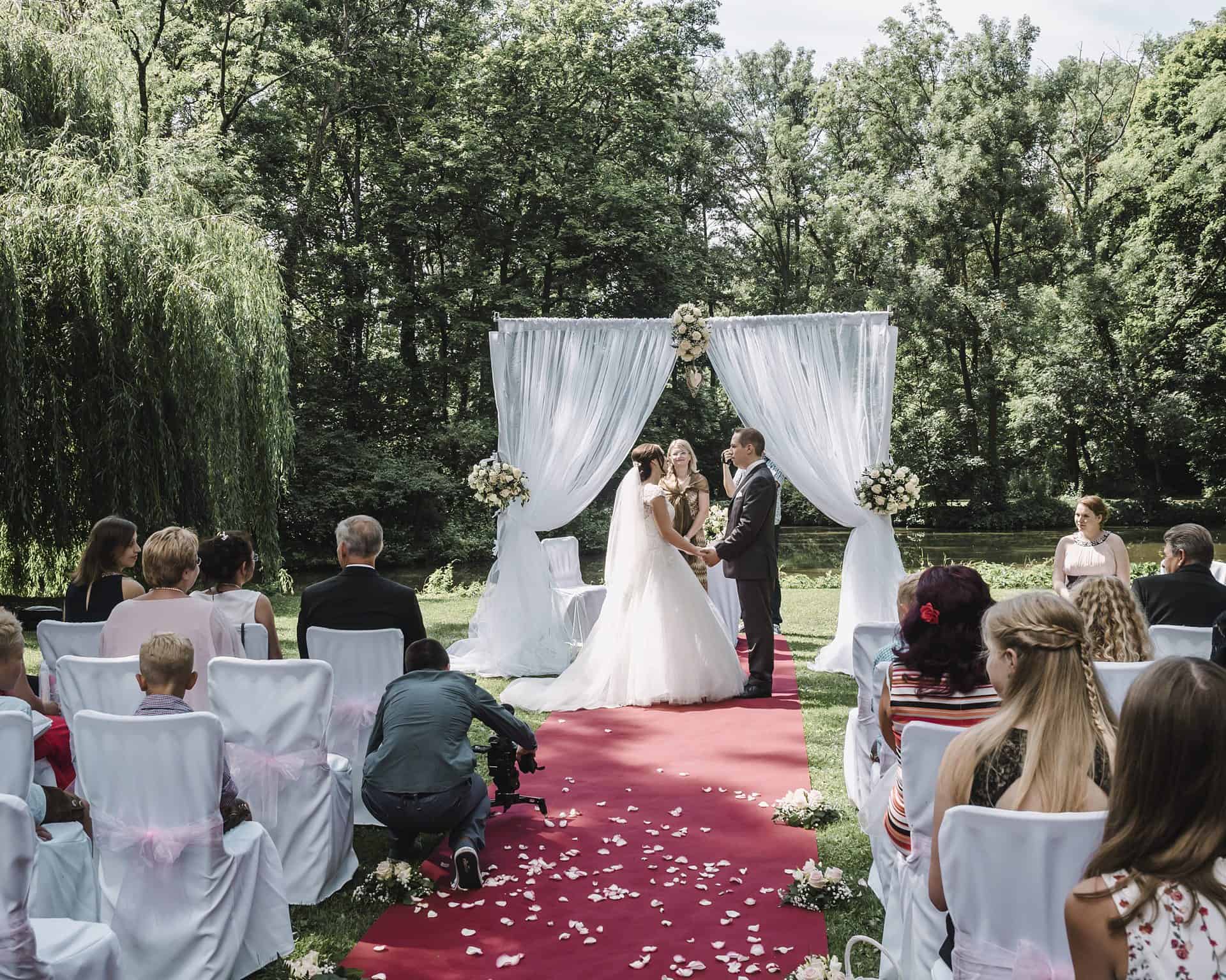 Eine Hochzeitszeremonie in einem Park mit Braut und Bräutigam.