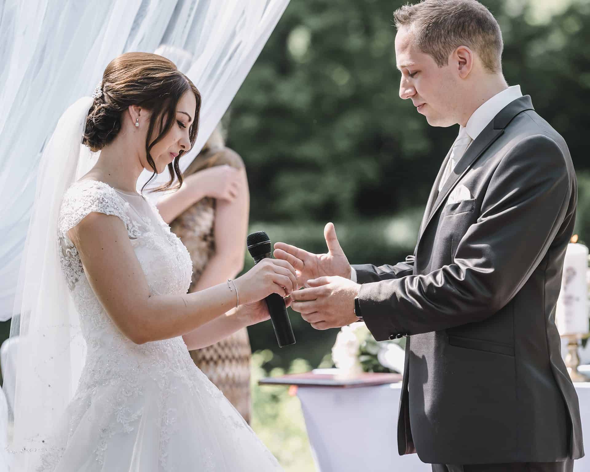 Ein Brautpaar tauscht während der Trauung die Ringe aus.