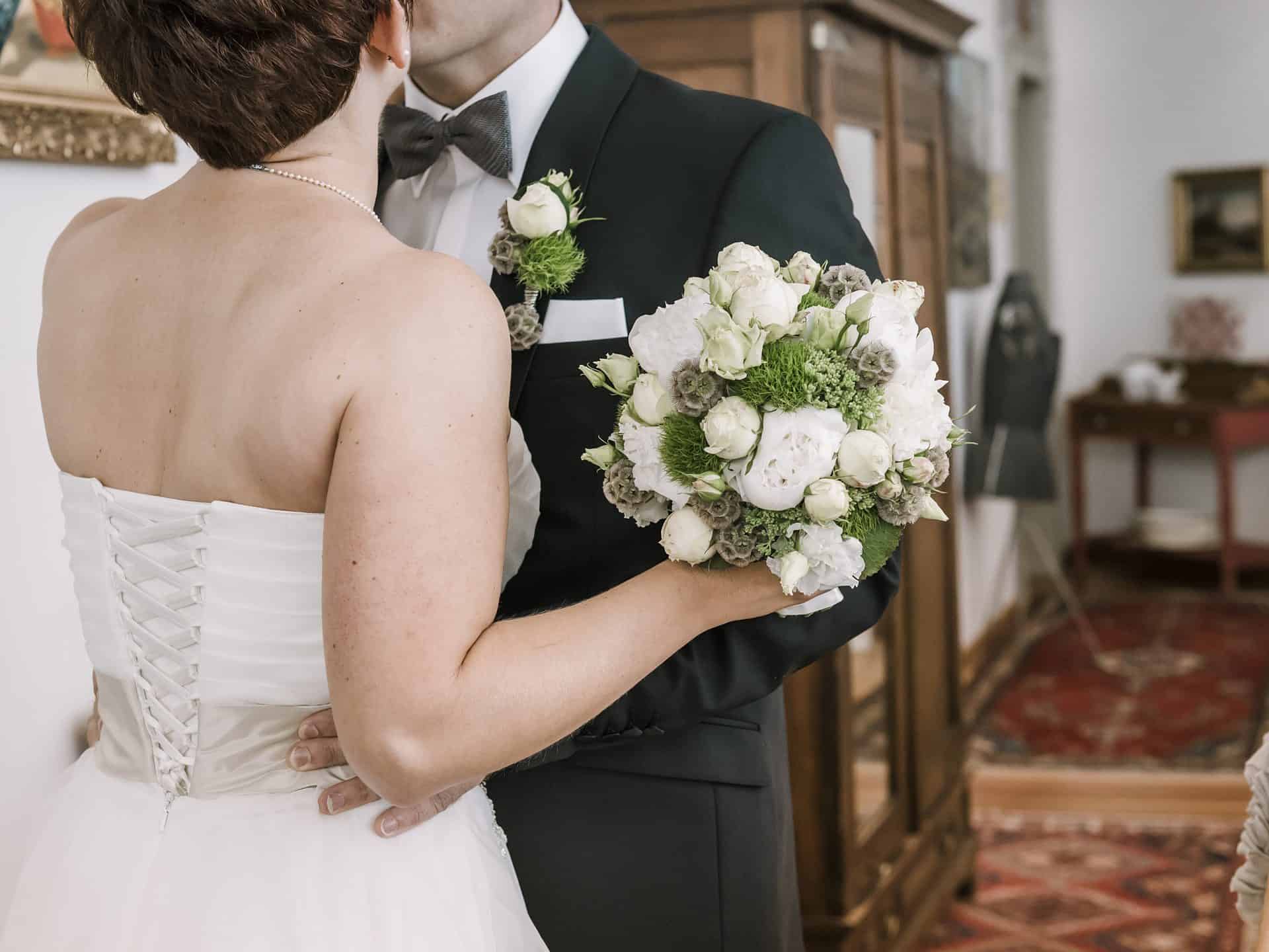 Eine Braut und ein Bräutigam küssen sich vor einem Spiegel.