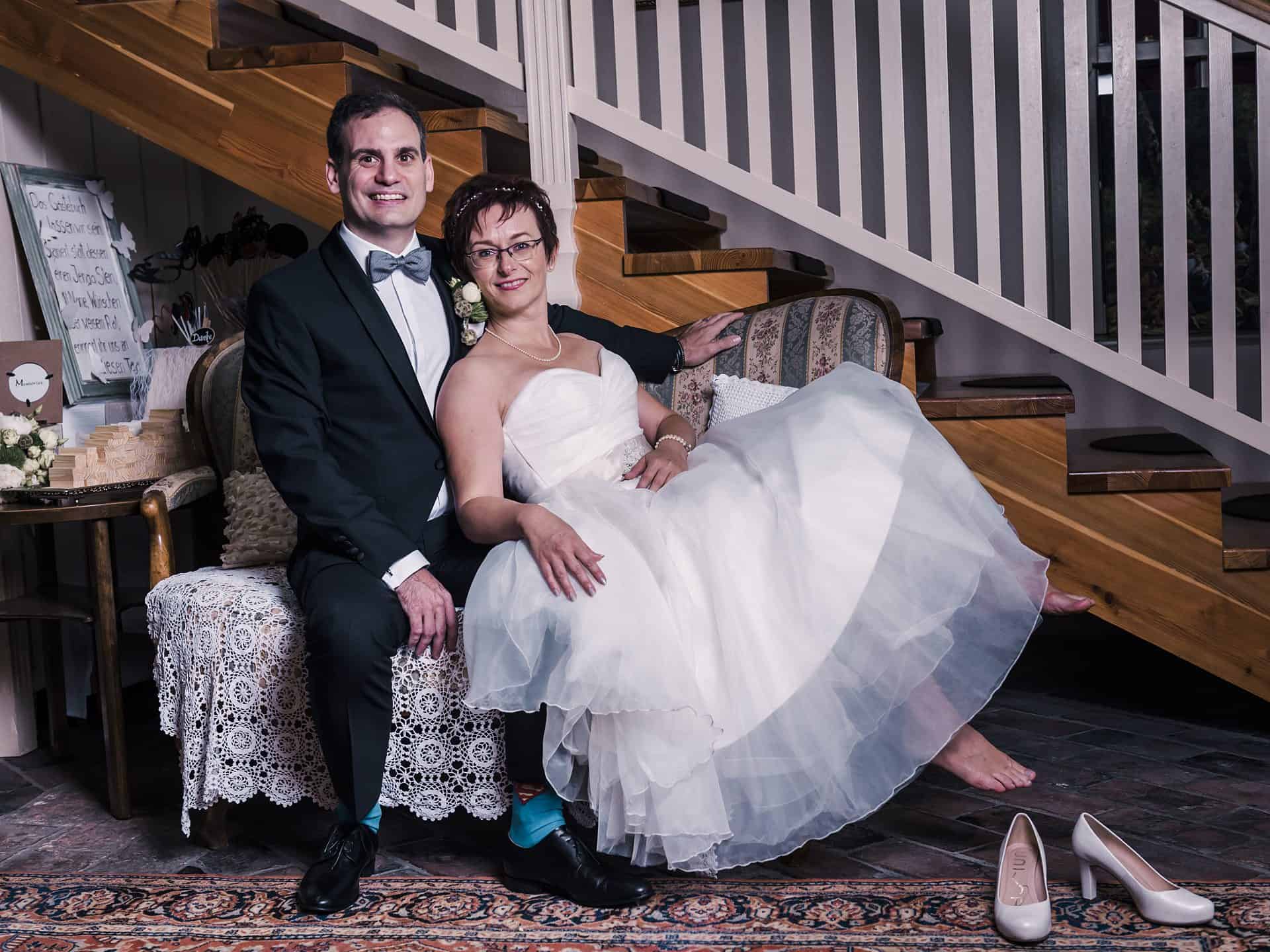 Eine Braut und ein Bräutigam posieren für ein Foto vor einer Treppe.