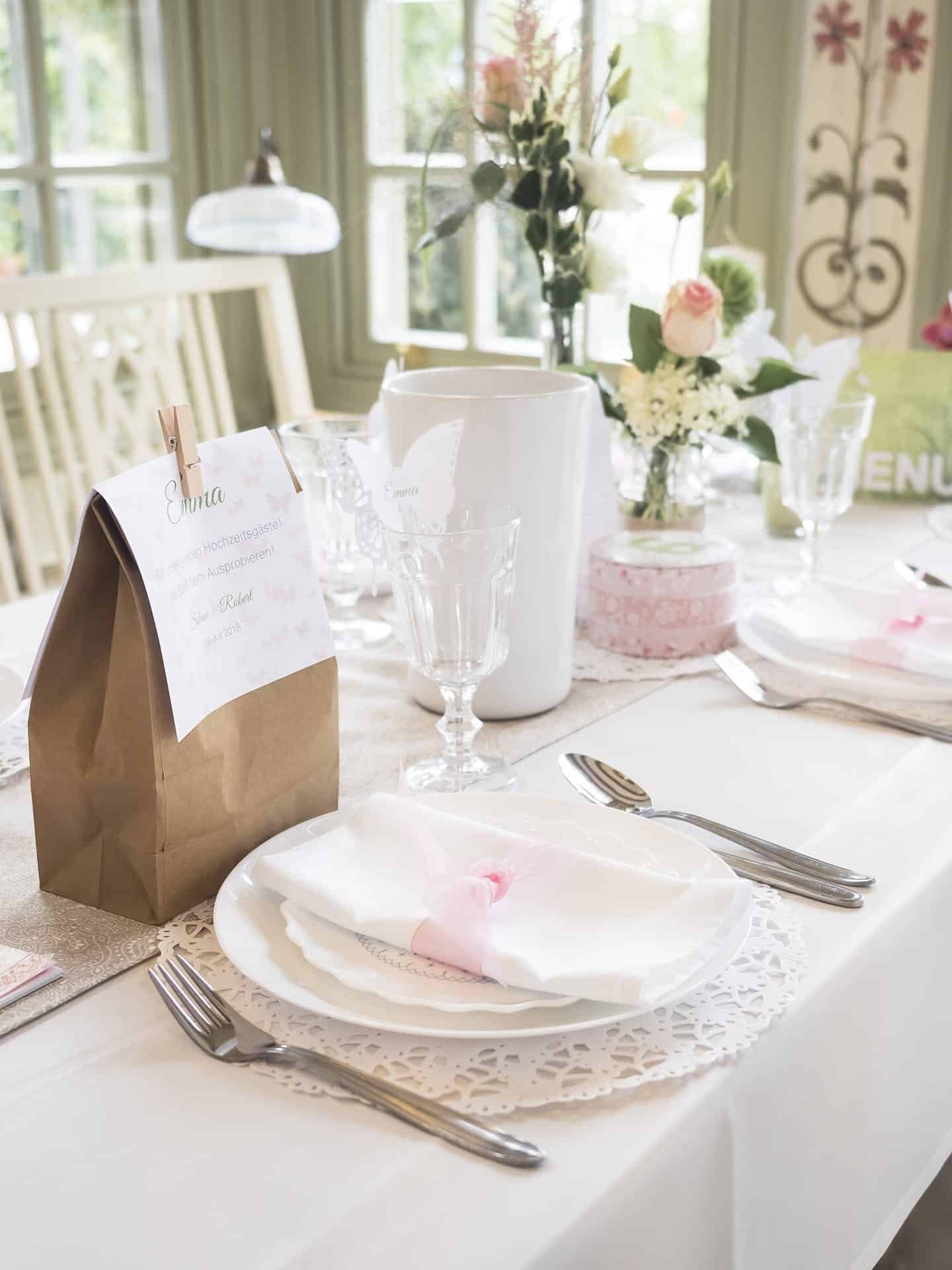 Ein gedeckter Tisch mit weißen Tellern und Servietten.