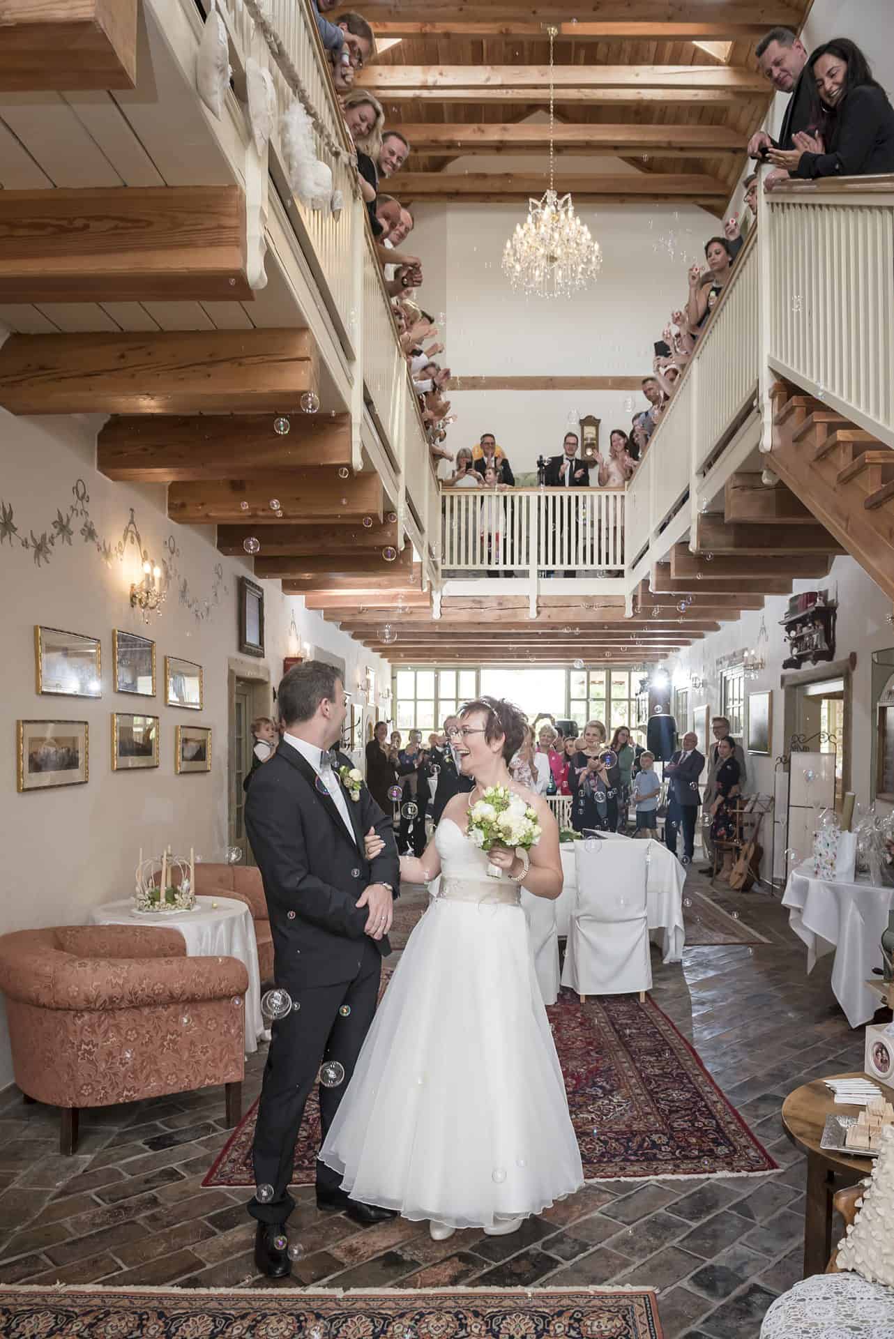 Ein Brautpaar steht vor einer Treppe.