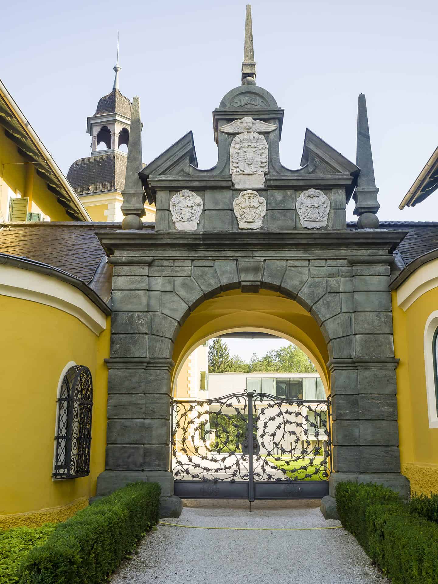 Der Eingang zu einem gelben Gebäude mit einem verzierten Tor.