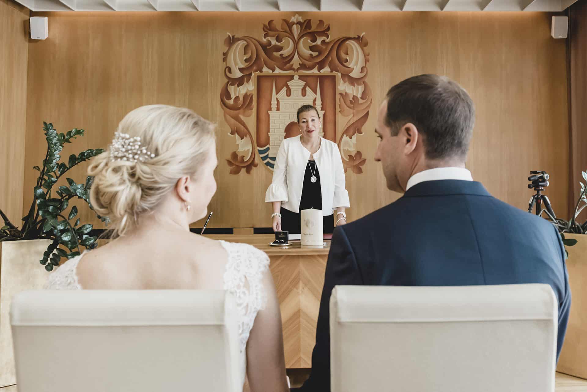 Ein Brautpaar sitzt vor einem Richter in einem Gerichtssaal.