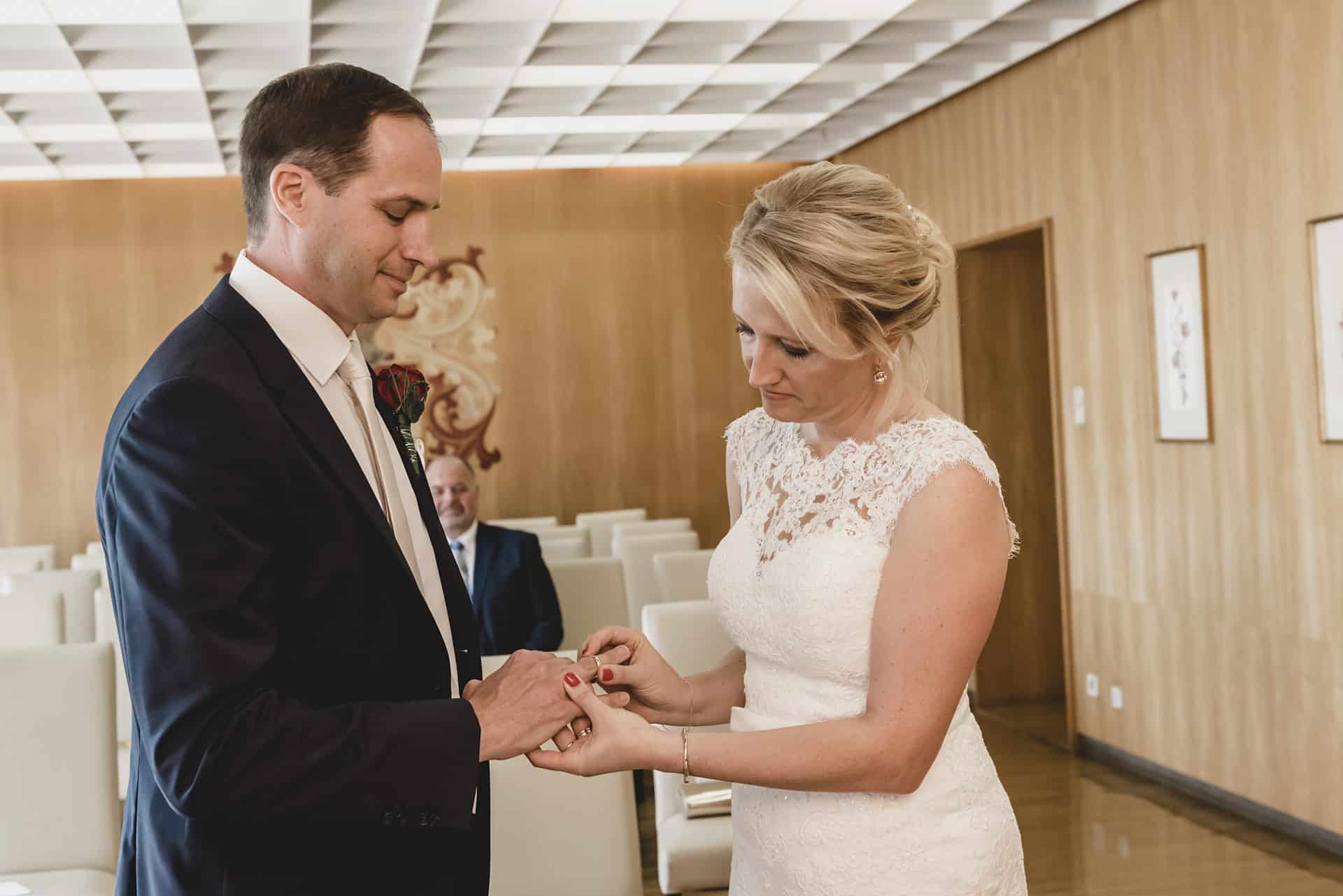 Eine Braut und ein Bräutigam tauschen in einem Raum ihre Ringe aus.