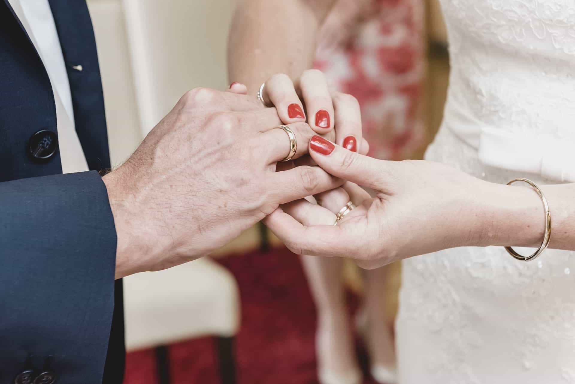 Ein Mann steckt einer Frau einen Ehering an den Finger.
