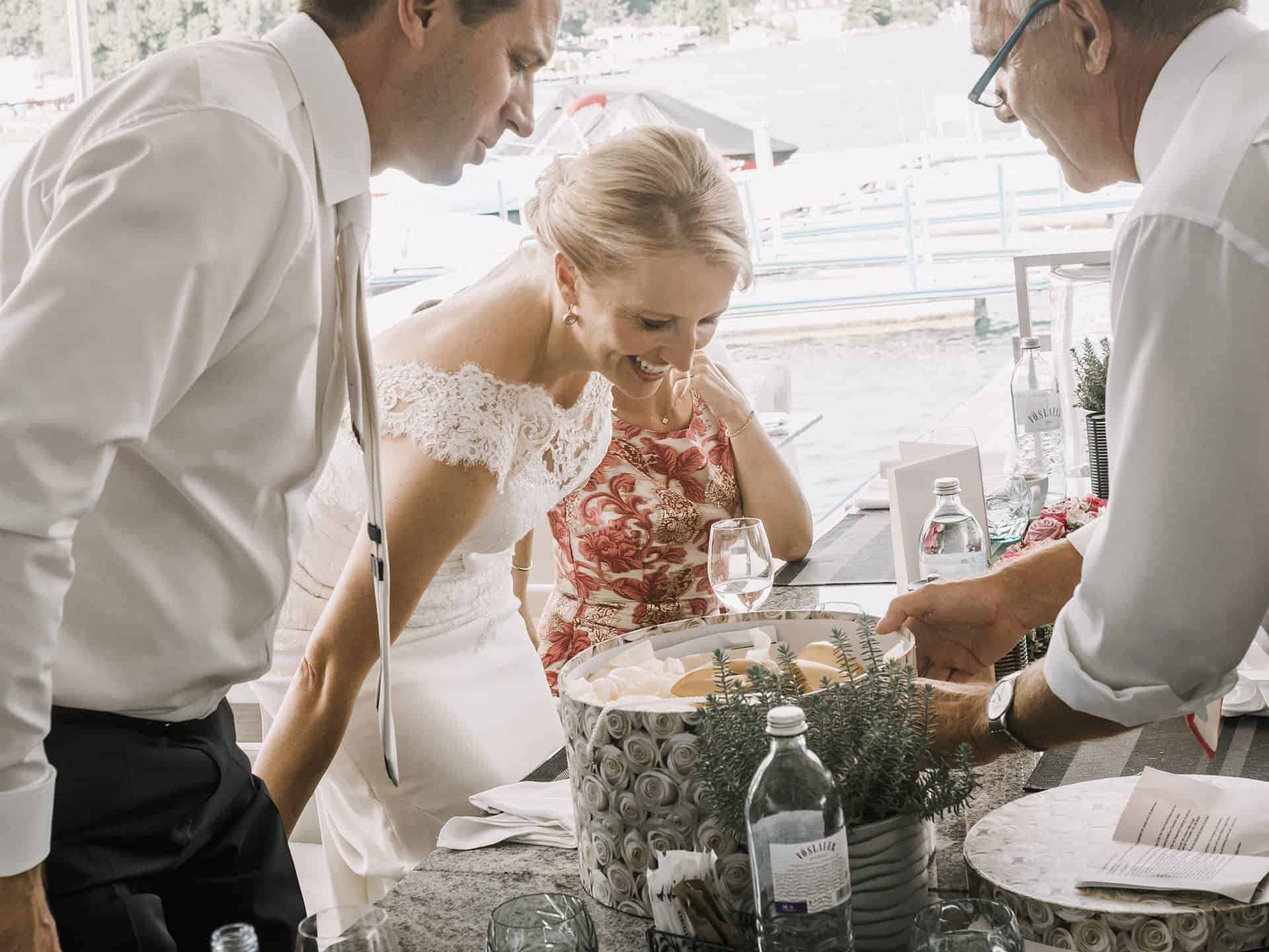 Ein Brautpaar schenkt an einem Tisch Getränke ein.