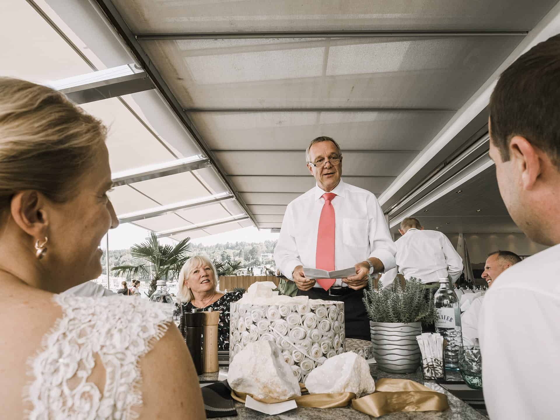 Ein Mann spricht auf einer Hochzeit einen Toast aus.