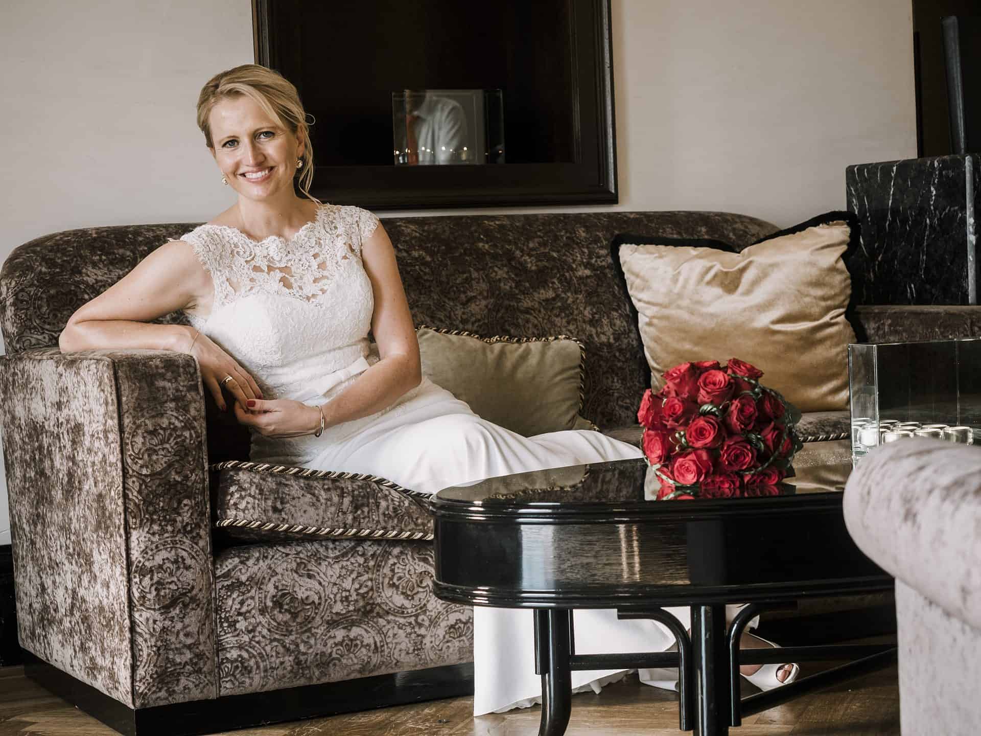 Eine Braut sitzt auf einer Couch in einem Hotelzimmer.