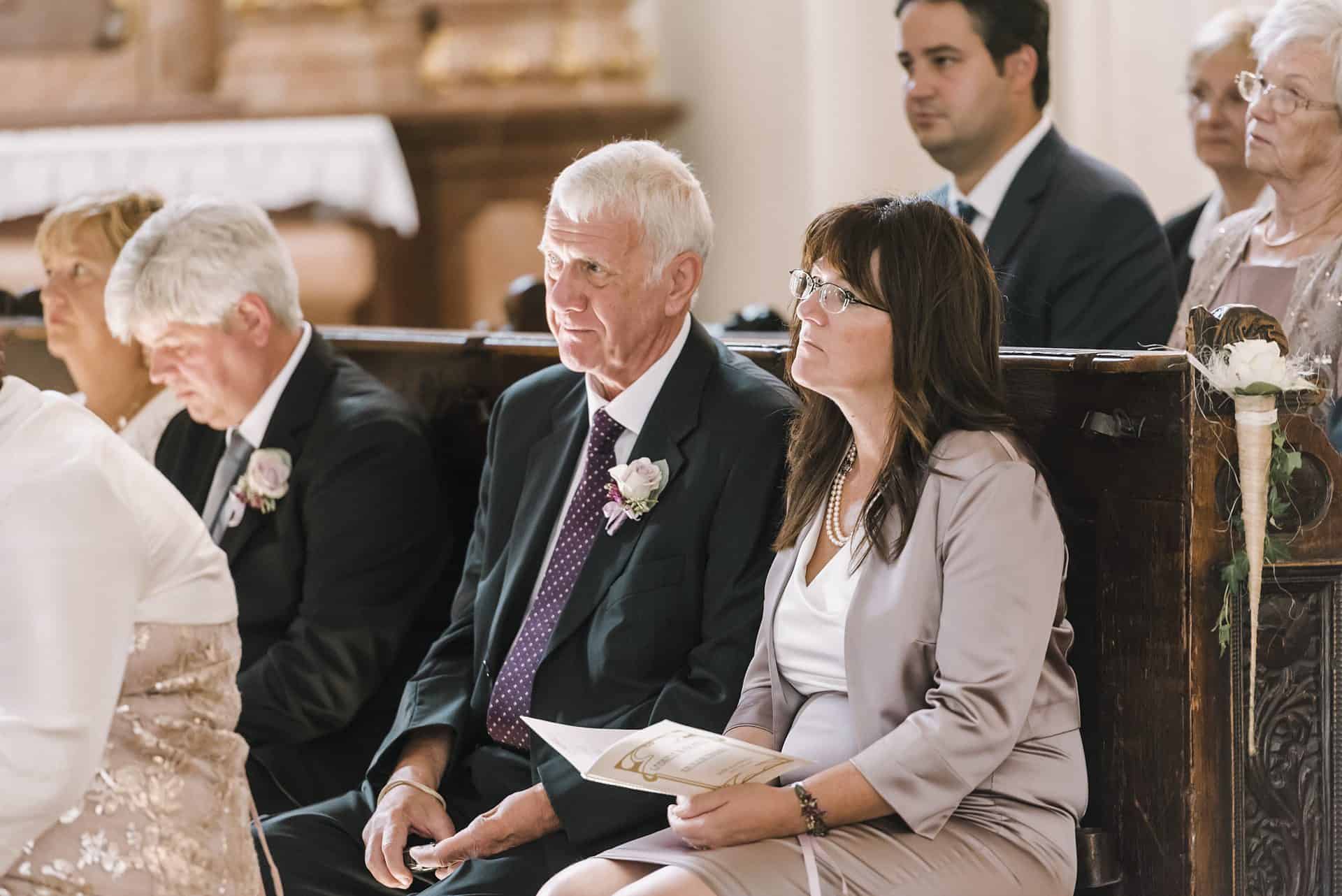 Eine Hochzeitszeremonie in einer Kirche mit Menschen, die in den Kirchenbänken sitzen.