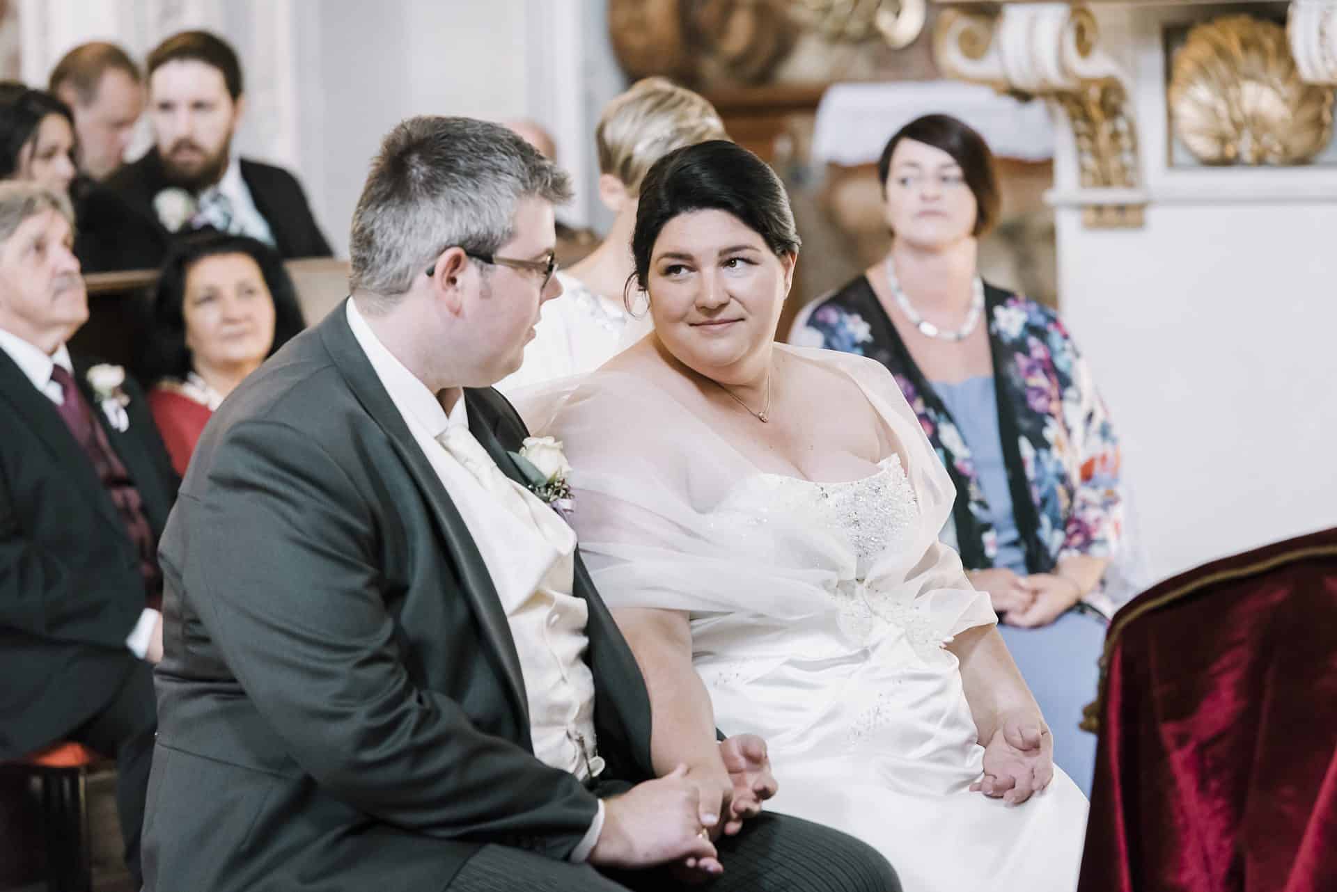 Eine Braut und ein Bräutigam schauen sich während ihrer Hochzeitszeremonie an.