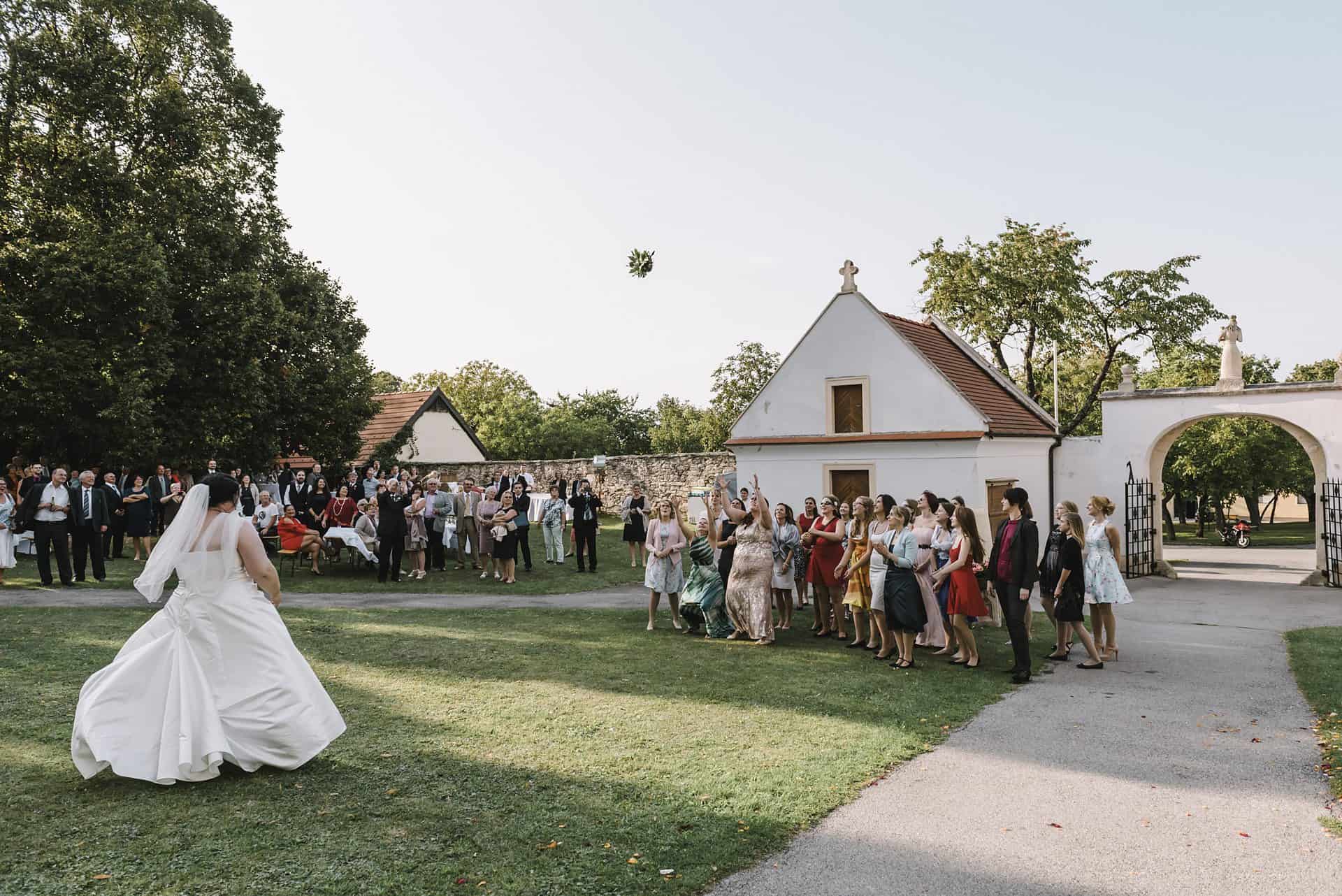 Eine Braut und ein Bräutigam werfen vor einer Menschenmenge einen Frisbee.
