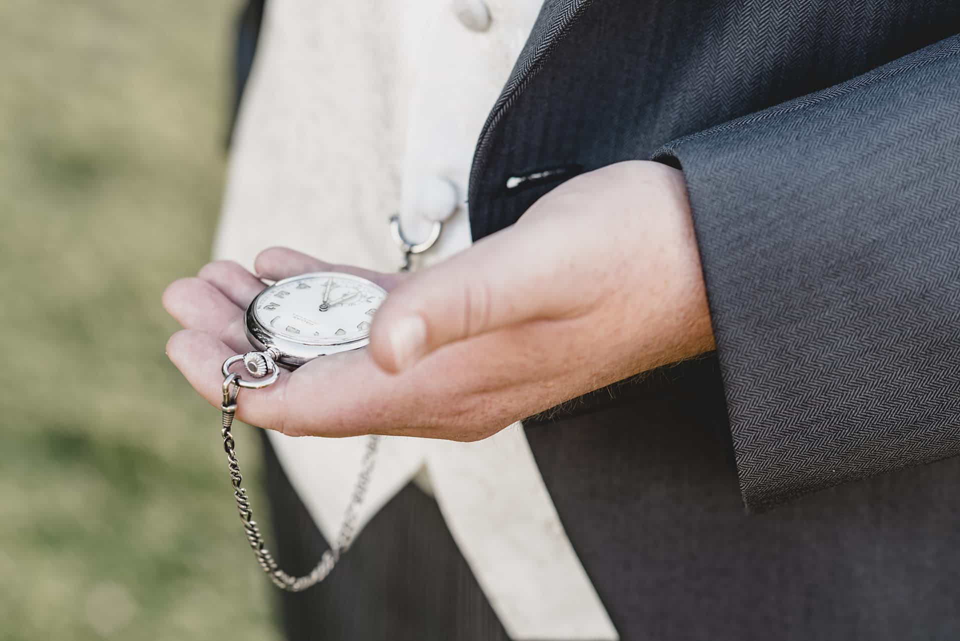 Ein Mann im Anzug mit einer Taschenuhr.
