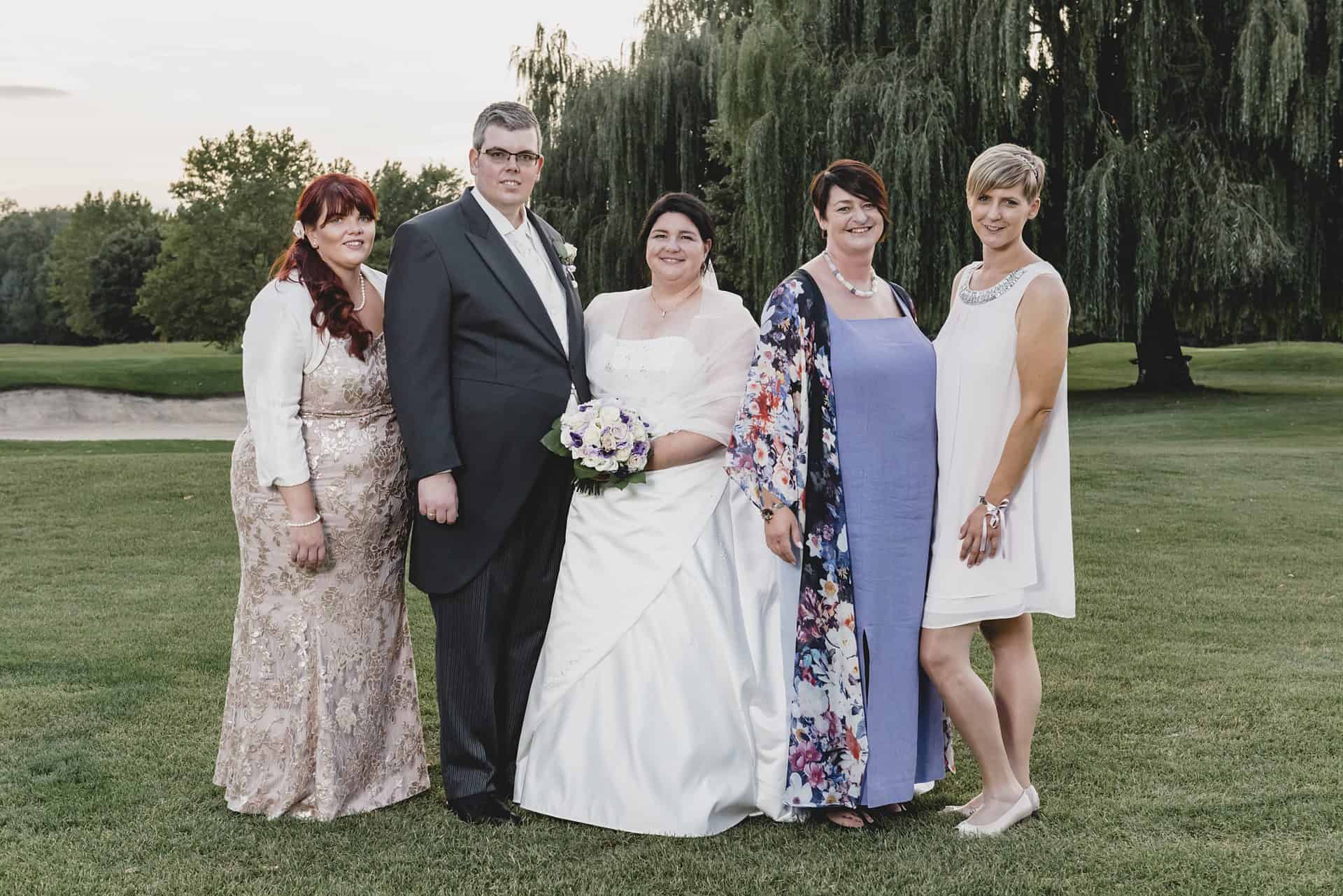 Eine Braut und ihre Brautjungfern posieren für ein Foto auf einem Golfplatz.