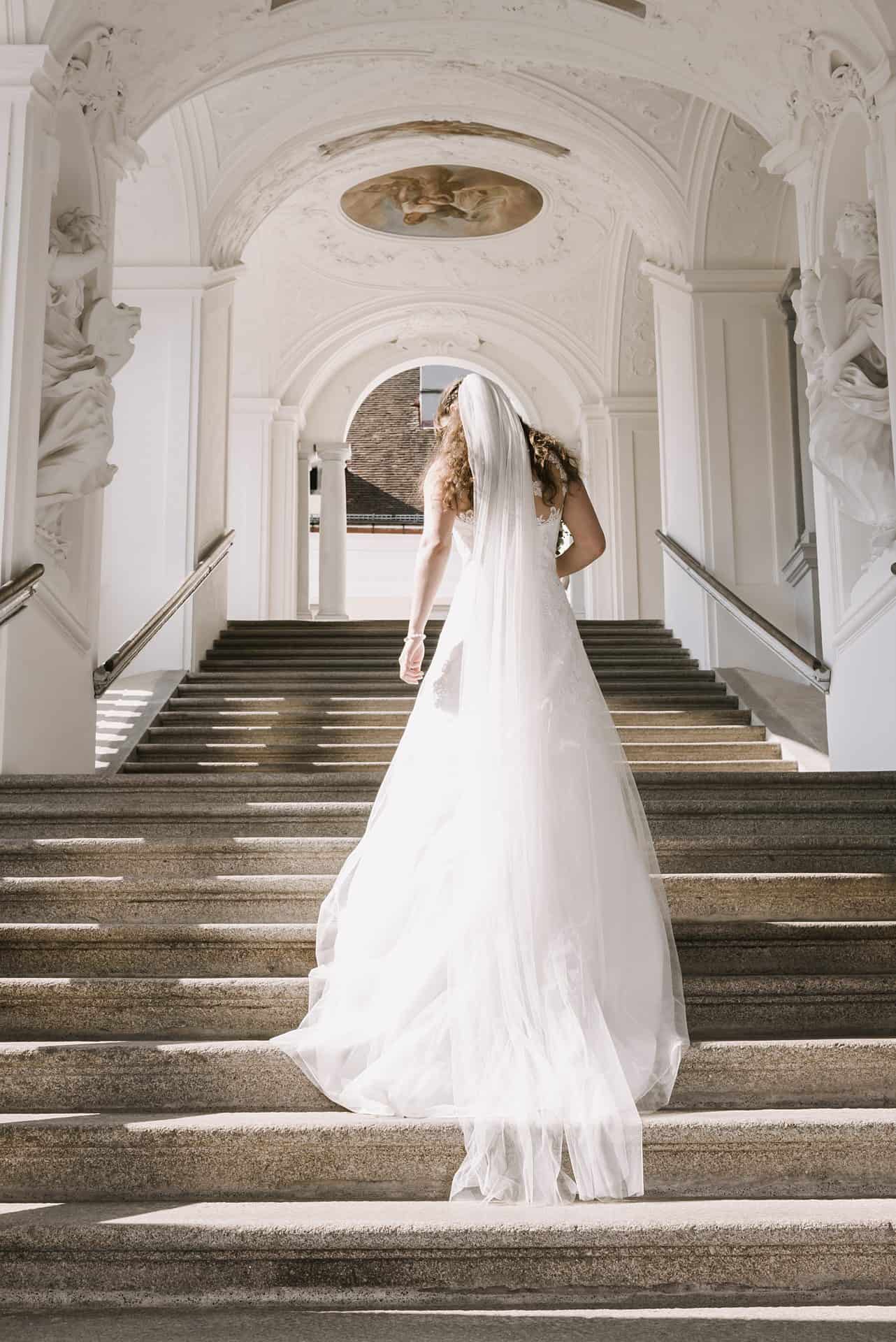Eine Braut geht die Treppe eines Gebäudes hinunter.