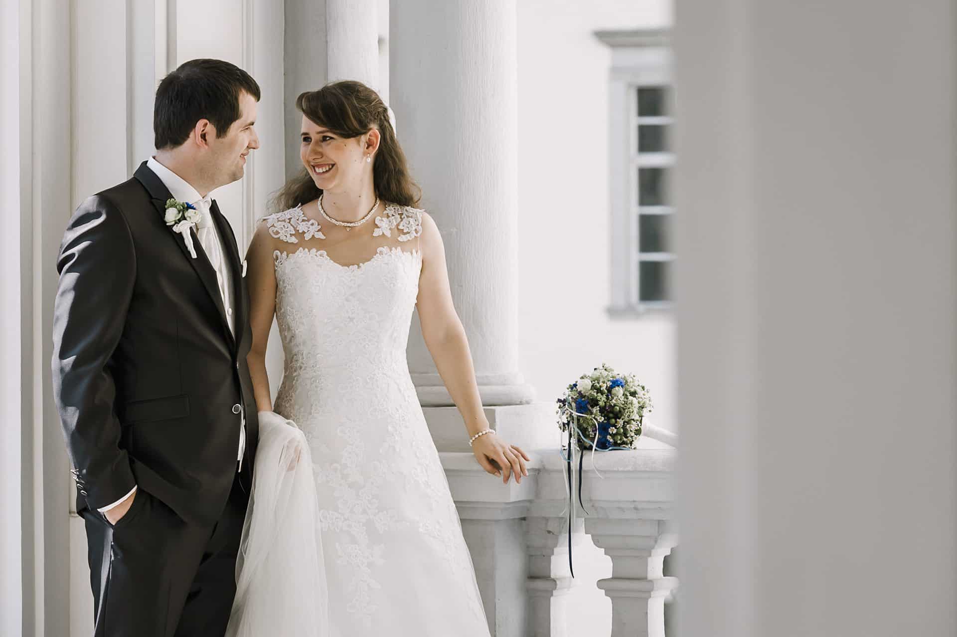 Eine Braut und ein Bräutigam stehen auf einem Balkon.