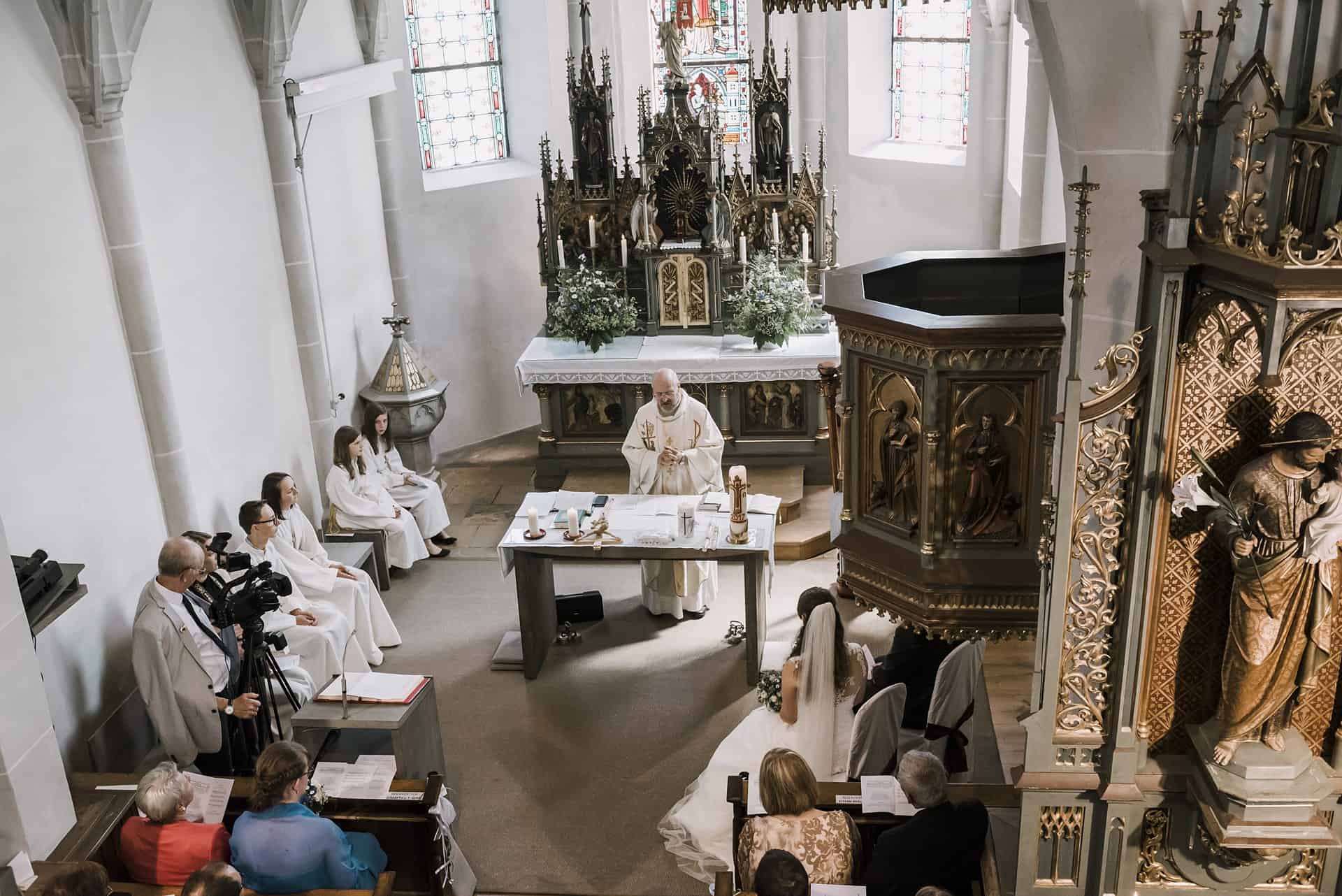 Eine Hochzeitszeremonie in einer Kirche mit einem Priester.