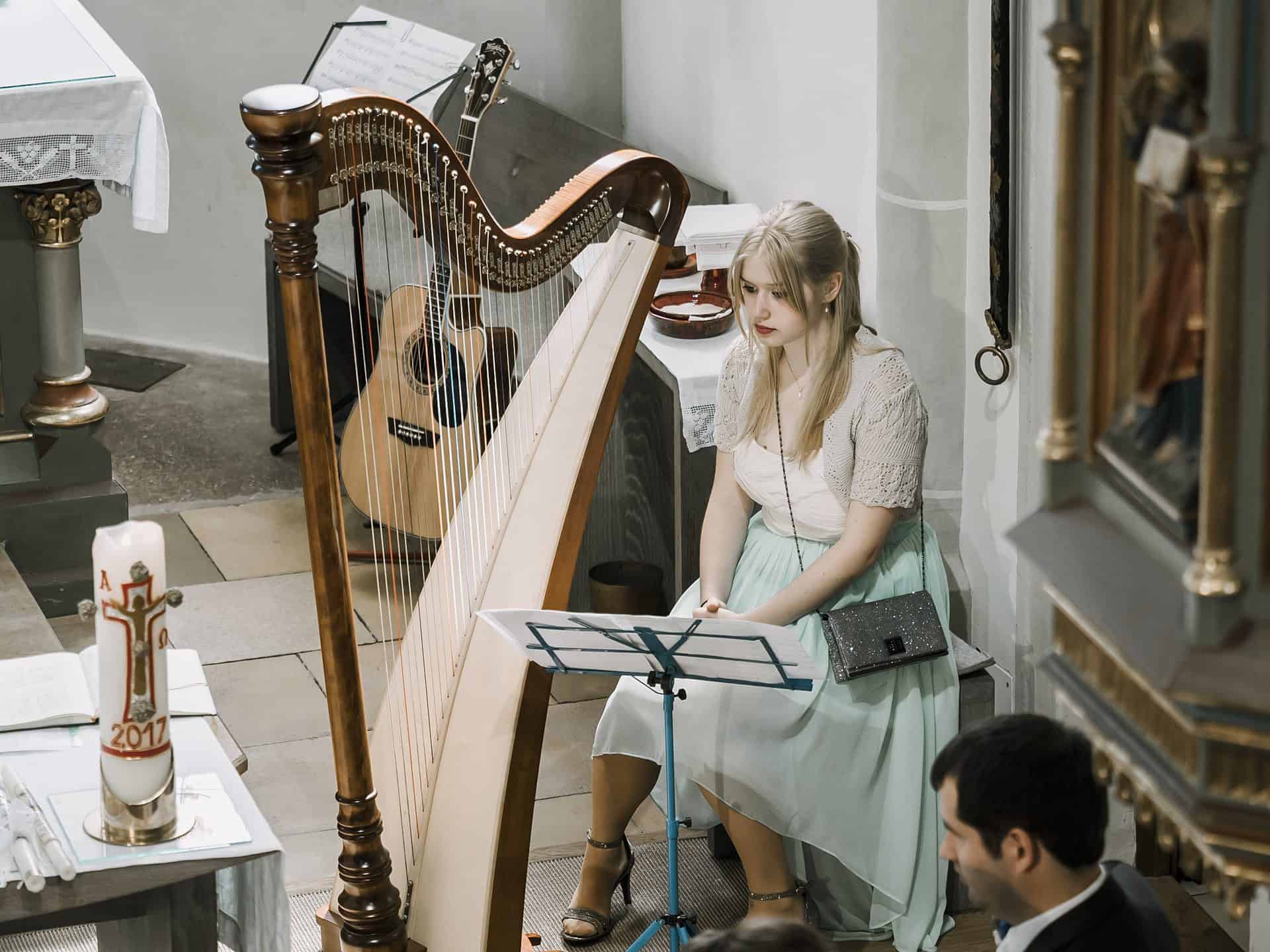 Eine Frau spielt Harfe in einer Kirche.