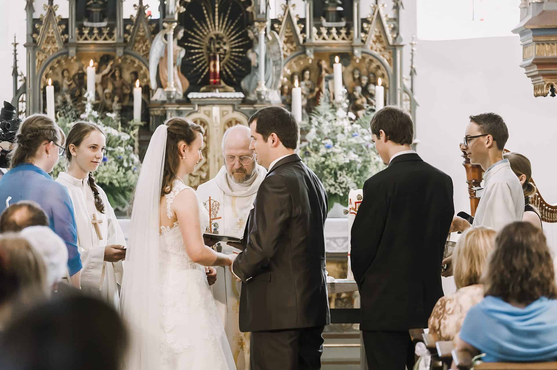 Eine Braut und ein Bräutigam geben sich in einer Kirche das Ja-Wort.