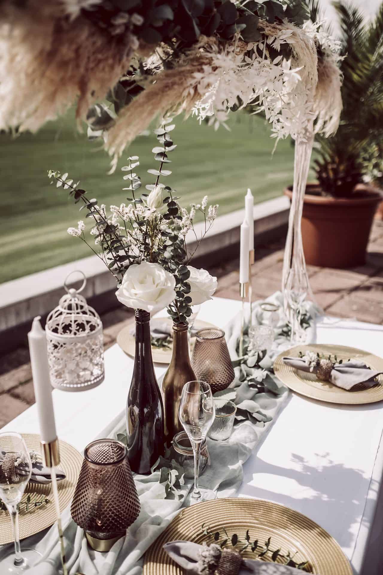 Ein gedeckter Tisch mit goldenen und weißen Tellern und Gläsern.