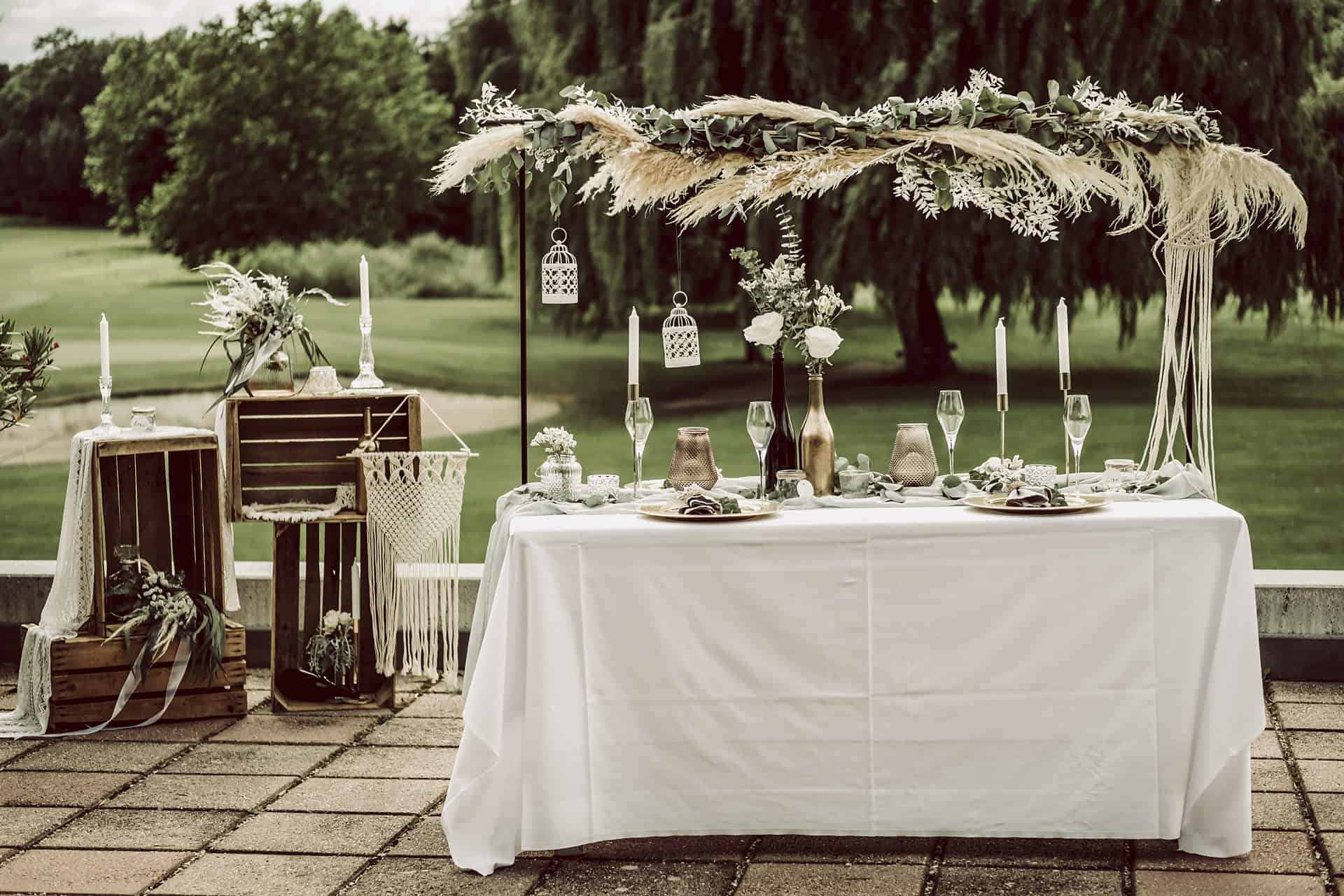 Ein für eine Hochzeit gedeckter Tisch mit Blumen und Kerzen.
