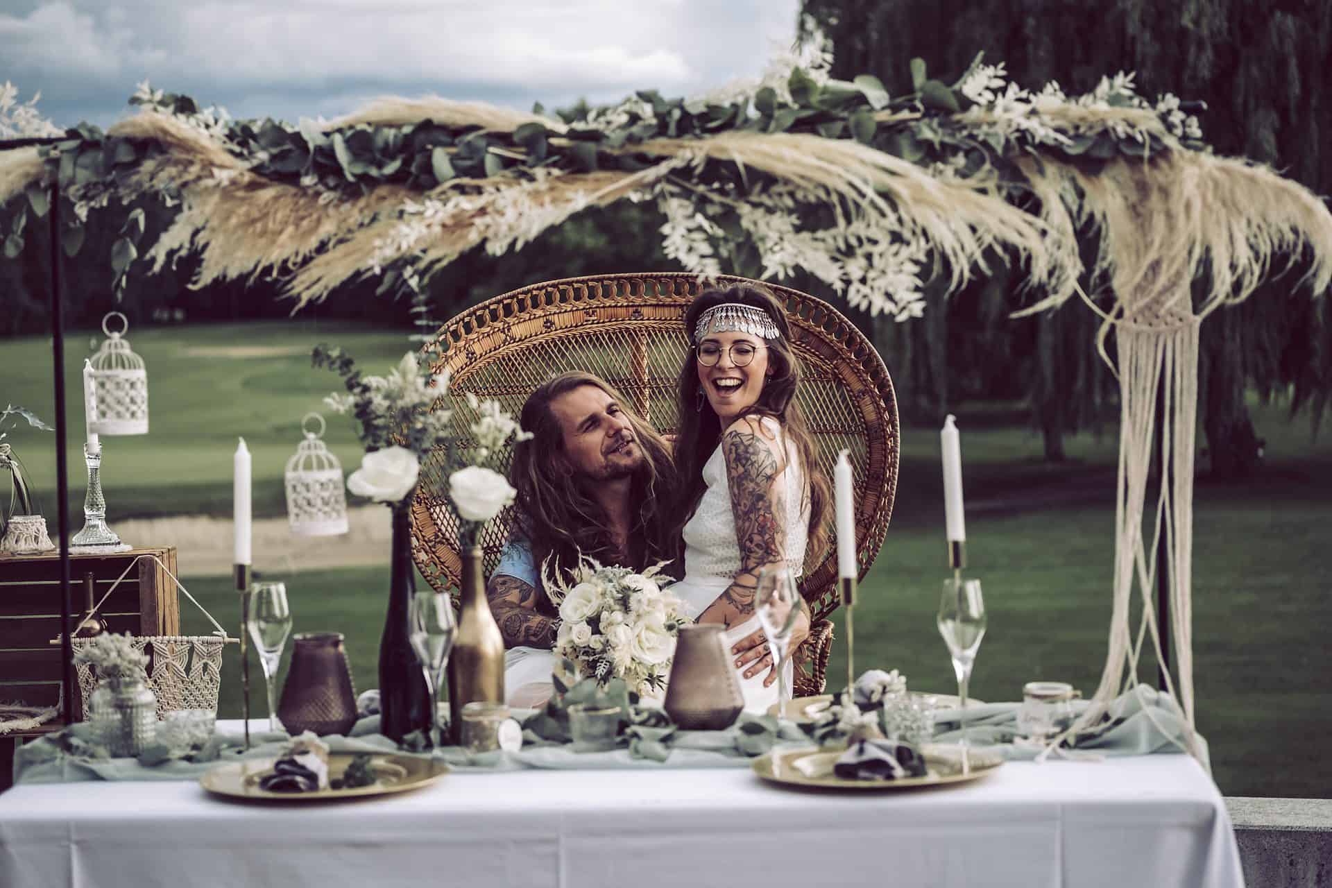 Eine Braut und ein Bräutigam sitzen an einem Hochzeitstisch.