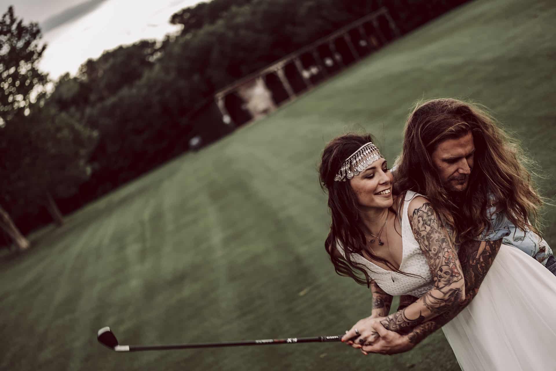 Eine Braut und ein Bräutigam umarmen sich auf einem Golfplatz.