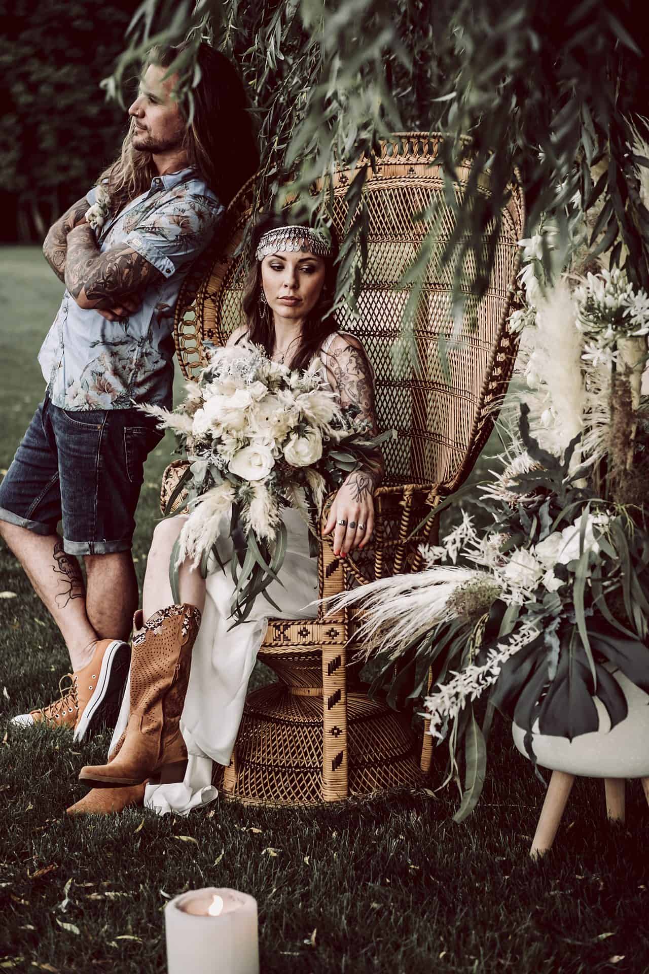 Eine Braut und ein Bräutigam sitzen in einem Korbstuhl.