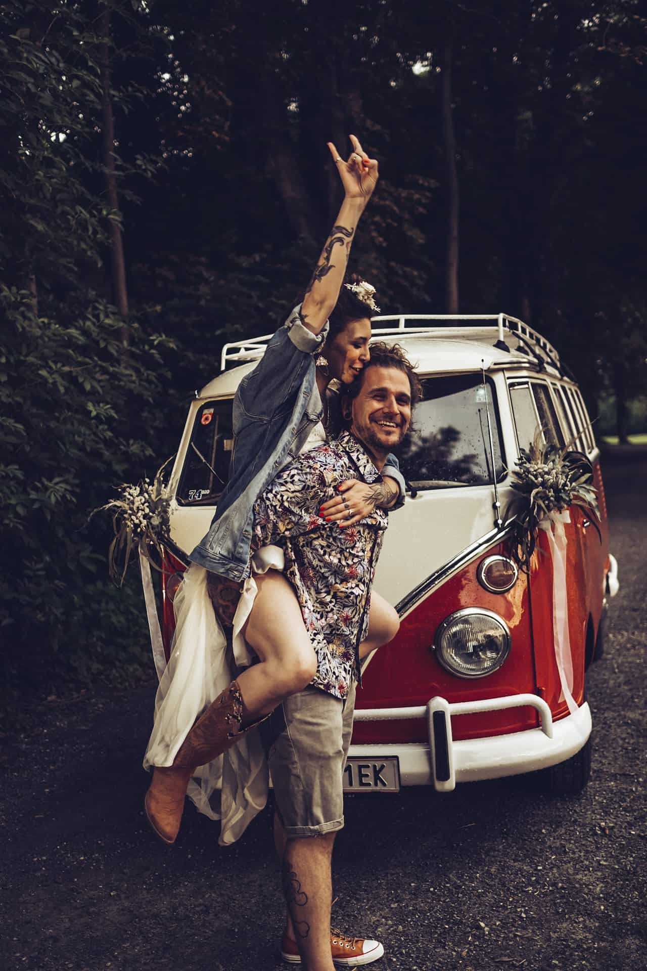 Ein Mann und eine Frau stehen neben einem VW-Bus.
