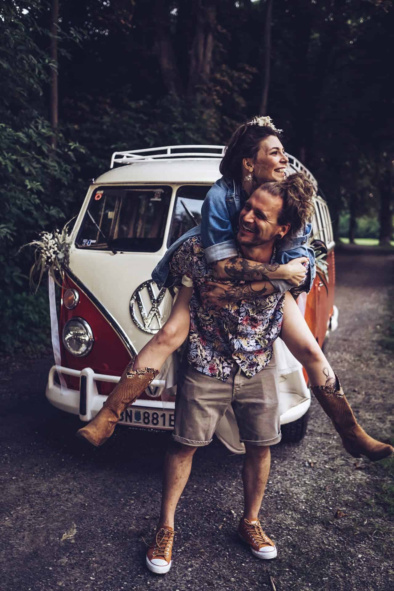 Ein Mann und eine Frau umarmen sich vor einem VW-Bus.